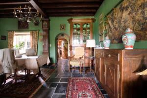 a dining room with green walls and a table and chairs at Hof ter Wallen in Zoutleeuw