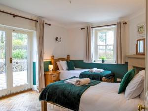 a bedroom with two beds with a dog laying on them at 7 Bed in Buxton oc-93808 in Tideswell