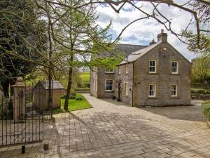 a large stone house with a fence in front of it at 7 Bed in Buxton oc-93808 in Tideswell