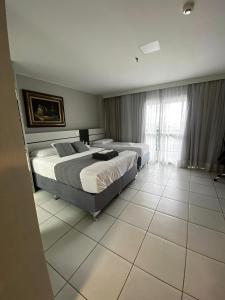 a bedroom with two beds and a large window at Flat com vista espetacular no centro de Brasília Vision Work and live in Brasília