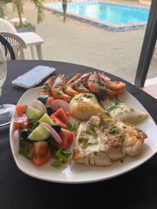 a plate of food with shrimp and vegetables on a table at Tida-Ecolodge in Kartung