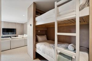 a bedroom with bunk beds and a living room at Rubus St Residence by Sothebys Luxury Rental Homes in Wanaka