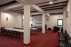 a conference room with white tables and chairs at Pensiunea Andreea in Baia de Fier +64 photos