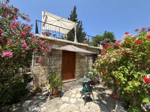 a house with a balcony and some flowers at Oleander Stone House in Lemona +21 photos