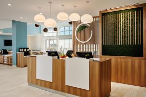 an office lobby with a reception desk and pendant lights at Element by Marriott Pooler Savannah Airport in Savannah