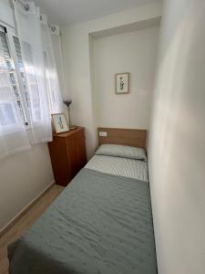 a small bedroom with two beds and a window at Apartamento Mar Blava Chilches in Chilches