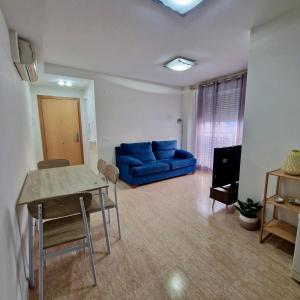a living room with a blue couch and a table at Apartamento Mar Blava Chilches in Chilches +7 photos