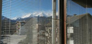 a view of a building through a window with blinds at Mountain View Apartment Bansko in Bansko