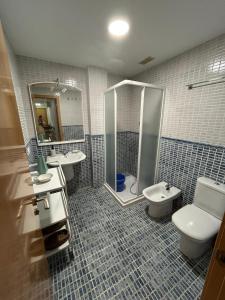 a bathroom with two sinks and a toilet and a shower at Apartamento Mar Blava Chilches in Chilches