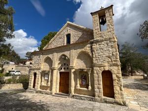 an old stone church with a tower and two doors at Oleander Stone House in Lemona