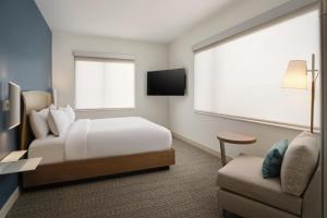 a hotel room with a bed and a chair at Element by Marriott Pooler Savannah Airport in Savannah +65 photos