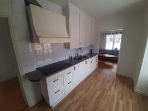 a kitchen with white cabinets and a black counter top at Nära lasarettet i Lindesberg in Lindesberg