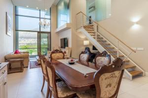 a dining room with a table and chairs and a staircase at V&A Waterfront Luxury by Nivar in Cape Town