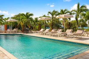 a swimming pool with lounge chairs and umbrellas at Parasasa Hotel Curacao in Willemstad