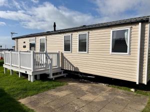 a mobile home with a porch and a staircase at Chesil View in Wyke Regis