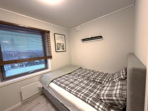 a small bedroom with a bed and a window at Modern brand new apartment Kongsberg in Kongsberg