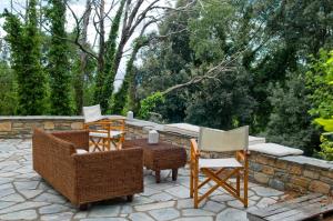 un patio con sillas de mimbre y una mesa con en Centaur Suites & Maisonettes en Miléai
