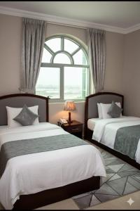 a hotel room with two beds and a window at BARAKAH HOTEl in Sharjah +33 photos