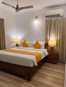 a bedroom with a large bed with yellow pillows at The Boho Inn in Cochin