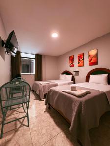 a hotel room with two beds and a television at HOTEL ALFONSO UGARTE in Chiclayo
