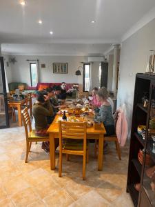 a group of people sitting around a wooden table at DAR LOUKA - atlas retreat en terre berbère in Tahannout