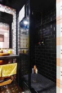 a bathroom with a shower with a black brick wall at Alojamiento Simón 2 in Murcia +39 photos