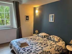 a bedroom with a bed with pillows and a window at Le chai de Peyssard, piscine chauffée. in Château-lʼÉvêque