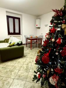 a christmas tree in a living room with a green couch at Il sentiero per Assisi in Bastia Umbra