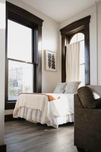 a bedroom with a bed and a chair and a window at The Neighborhood Lofts in Greencastle