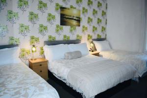 a bedroom with two beds and a wall with plants at The Franklyn Hotel B&B in Blackpool