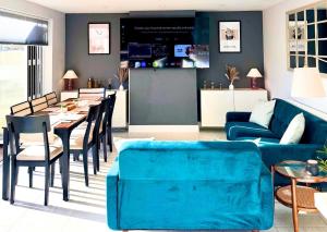 a living room with a blue couch and a table at The Lockside By Allsquare Stays 5BDR Heathrow M4 M25 M3 in Staines