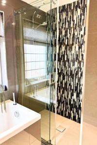 a bathroom with a glass shower with a sink and a tub at The Lockside By Allsquare Stays 5BDR Heathrow M4 M25 M3 in Staines