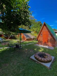 a small cabin with a fire pit in the grass at Casa Santa Teresita in El Progreso