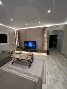 a large living room with a table and a tv at Izdihar Dalis Suites in Quai