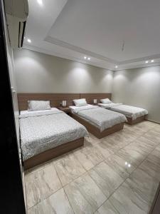a bedroom with two beds and a tiled floor at Izdihar Dalis Suites in Quai