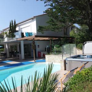 uma casa com uma piscina em frente em Villa Perle De La Mer em Saint-Aygulf