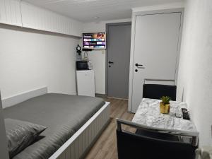 a bedroom with a bed and a table and a kitchen at Chambre confortable pour 2p in Ostend