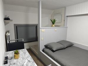 a bedroom with a bed and a flat screen tv at Chambre confortable pour 2p in Ostend