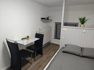 a small room with a table and chairs and a bed at Chambre confortable pour 2p in Ostend +12 photos
