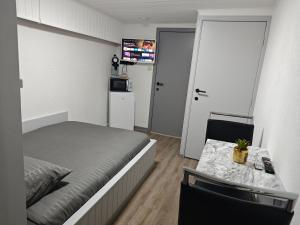 a bedroom with a bed and a table and a microwave at Chambre confortable pour 2p in Ostend