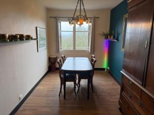 a dining room with a table and chairs and a rainbow at Les Hirondells in Limanton