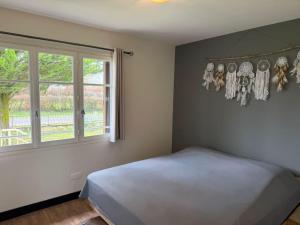 a bedroom with a bed and a window at Les Hirondells in Limanton