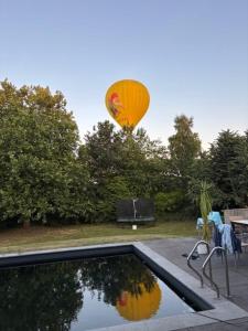 ein Heißluftballon, der über einem Schwimmbecken fliegt in der Unterkunft Aikje in Nazareth