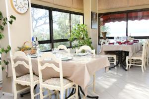 a dining room with white tables and chairs and a clock at Teras Motel 12 Adults Only in Foça +94 photos