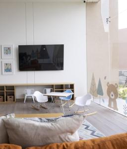 a living room with a tv and a table and chairs at Executive Loft - Gym - Home Office - Zibatá in La Cañada