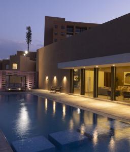 a swimming pool in front of a building at night at Executive Loft - Gym - Home Office - Zibatá in La Cañada
