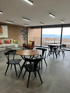 a living room with tables and chairs and a couch at Executive Loft - Gym - Home Office - Zibatá in La Cañada