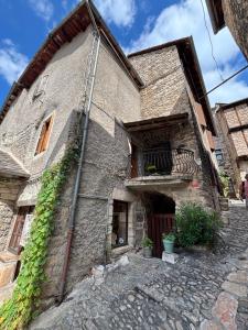 an old stone building with ivy growing on it at Logement Sainte-Énimie in Sainte-Énimie