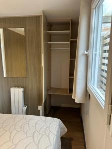 a small bedroom with a bed and a window at Mobil-home 1 in Quimper
