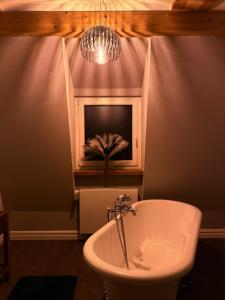 a bathroom with a white tub and a chandelier at Deluxe Loft in Bad Kissingen +7 photos